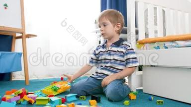 小男孩在房间里玩五颜六色的积木和积木时，心烦意乱，伤心起来